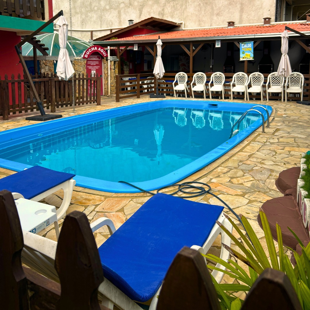 Piscina da Vila D’Itália cercada por varandas de madeira e telhados de barro